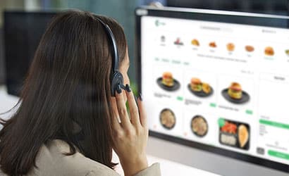 Support agent wearing a headset and using an online ordering platform